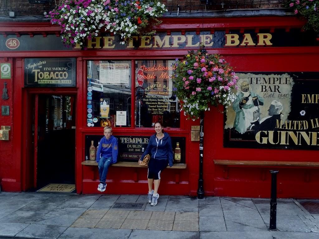 boy and young woman sitting outside red temple bar pub
