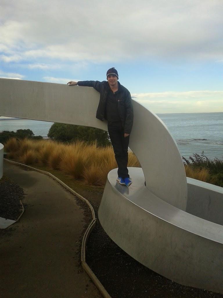 Man on chain sculpture Stirling Point Bluff New Zealand