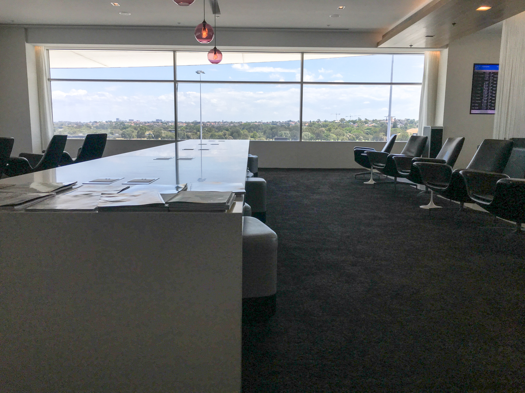 long white table in Sydney Koru Lounge with grey chairs