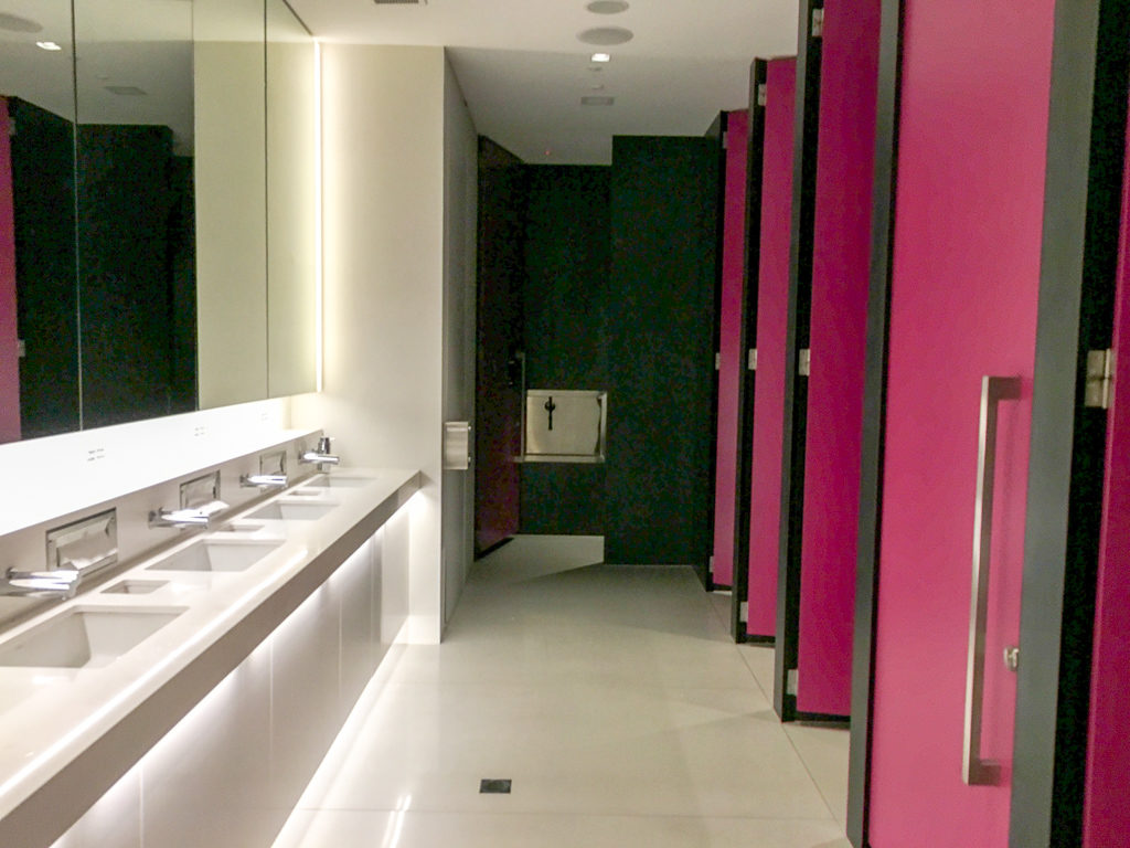 pink toilet cubical doors in airport lounge bathroom