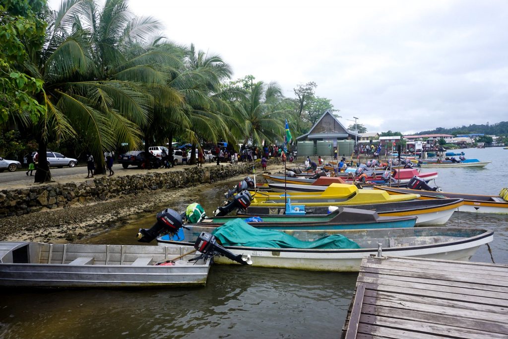 colourful banana boats lined up at waters edge