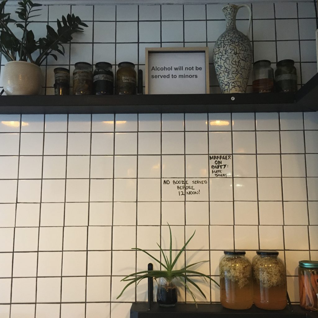 white tile wall with homemade preserves on shelves