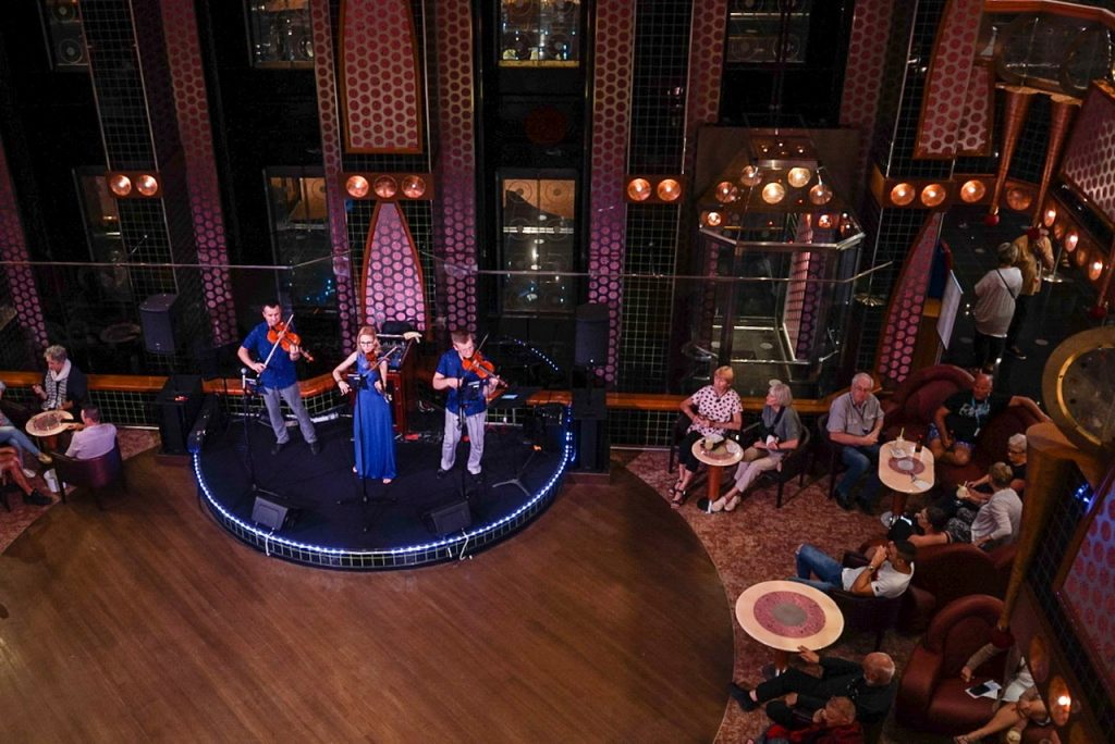 three member string band perform in lobby on Carnival Splendor
