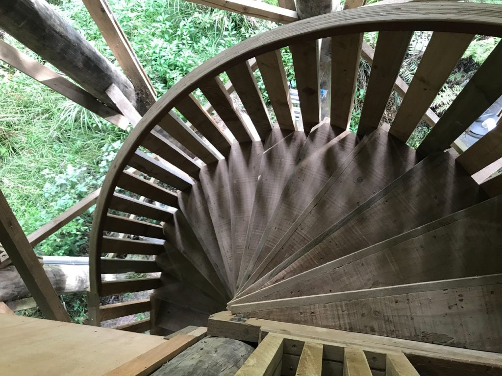winding untreated wooden staircase going down