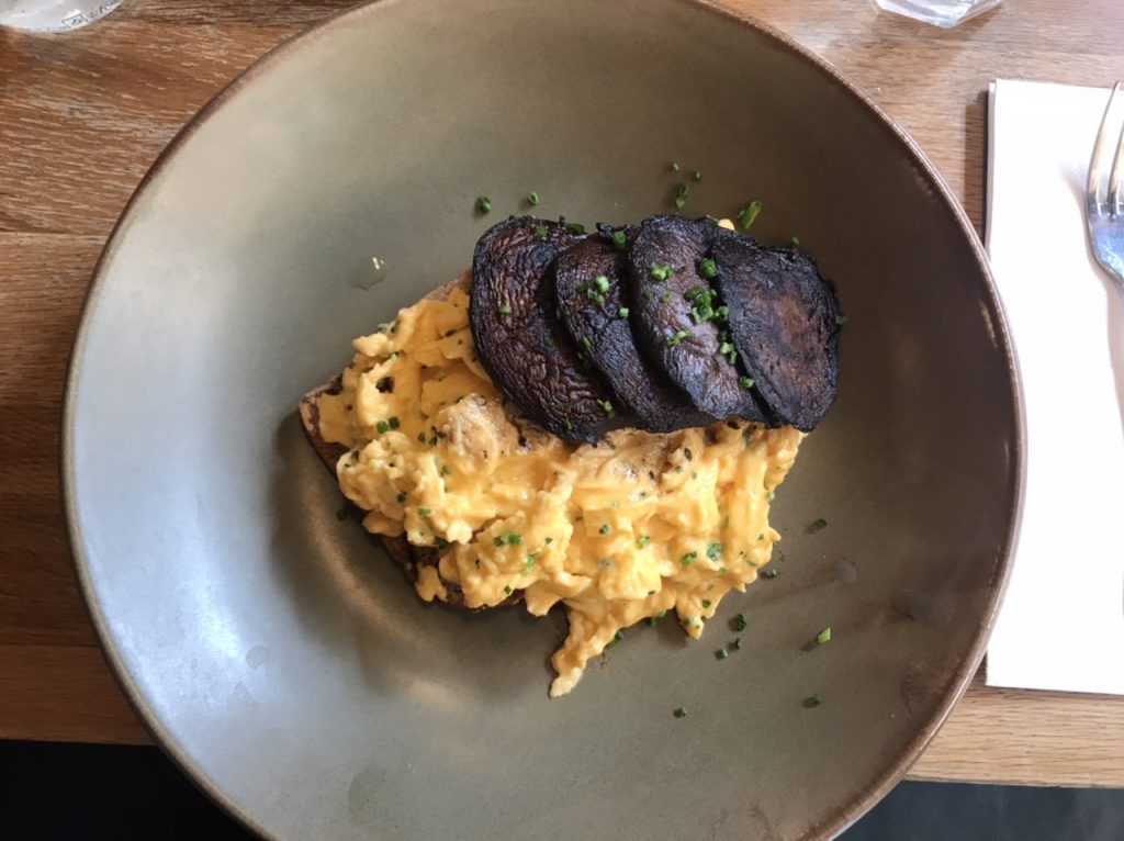 Truffled Eggs with four Mushrooms on gluten free bread with chives on grey dish