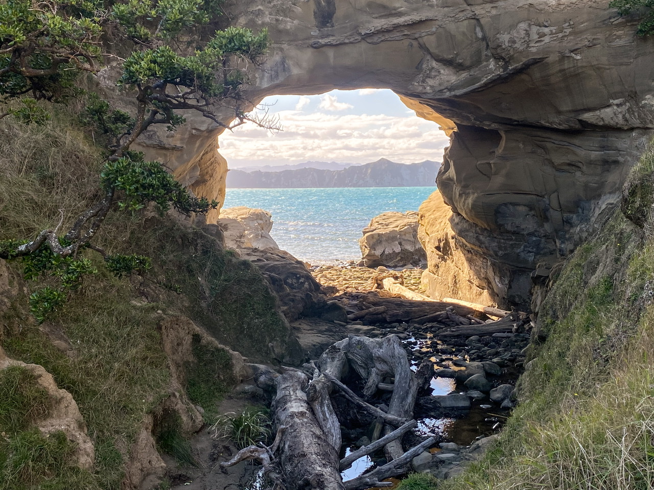 Hole in a rock at cooks cove with Tolaga Bay ocean behind