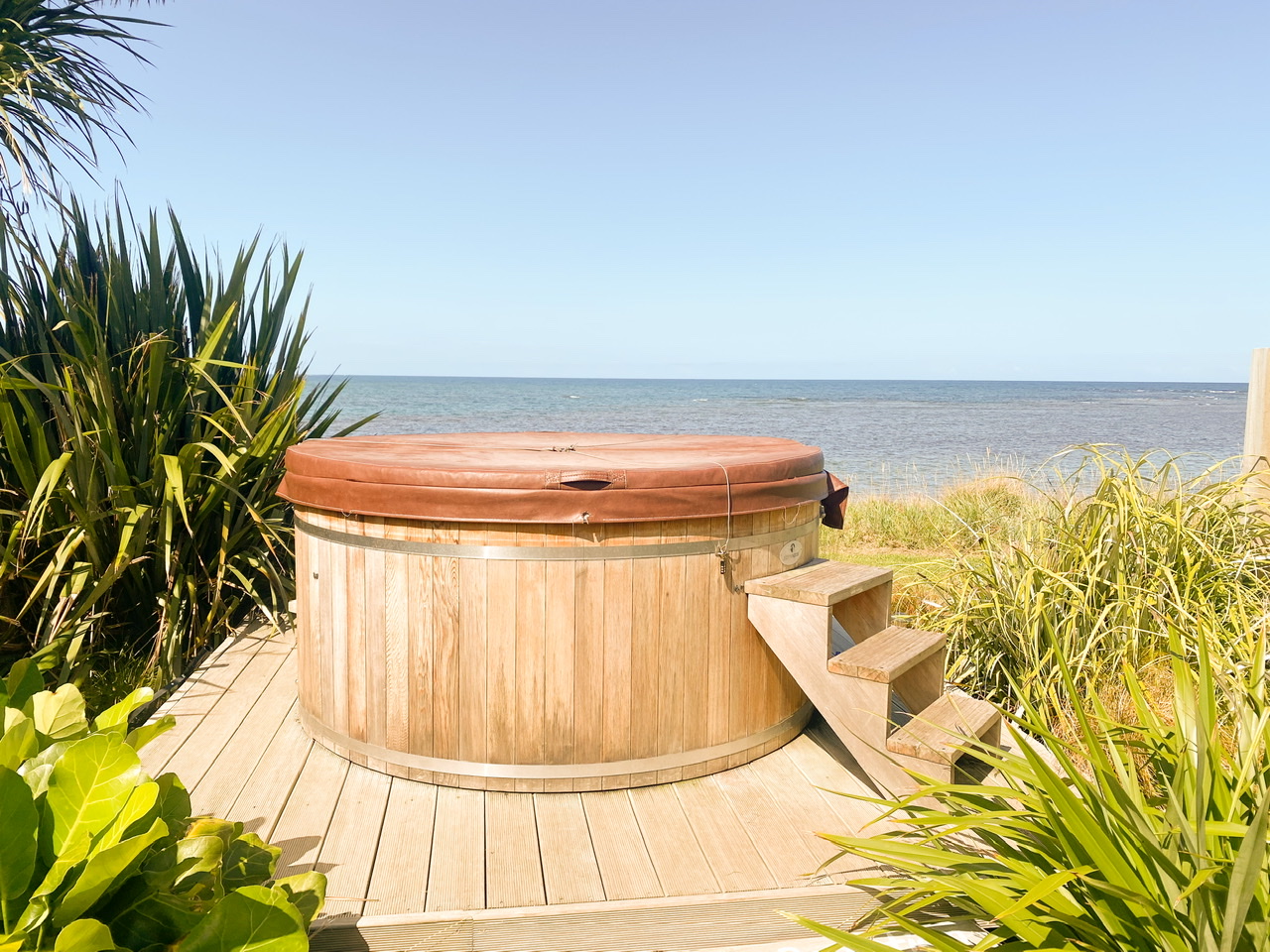 Hot tub with brown cover in front of ocean