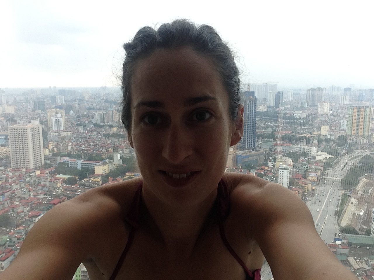 young woman taking a selfie of view from poolside at Lotte Hotel Hanoi