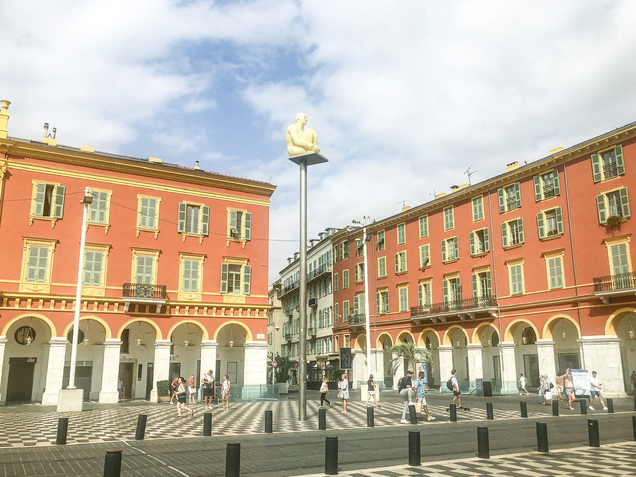 three light post sculptures and two pink buildings in Place Massena Nice