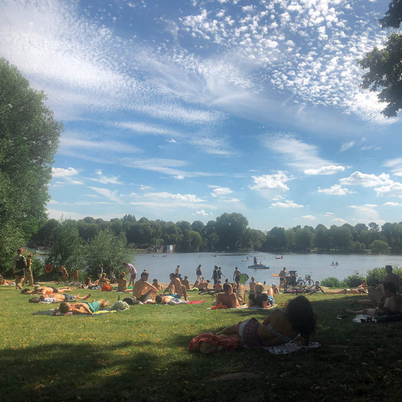 View of lake and people on grass in Stadtpark