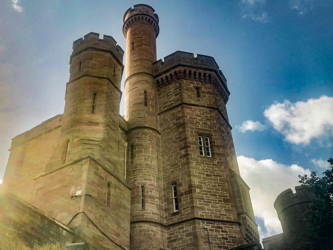 Four turrets of Inverness castle looking up against cloudy blue sky