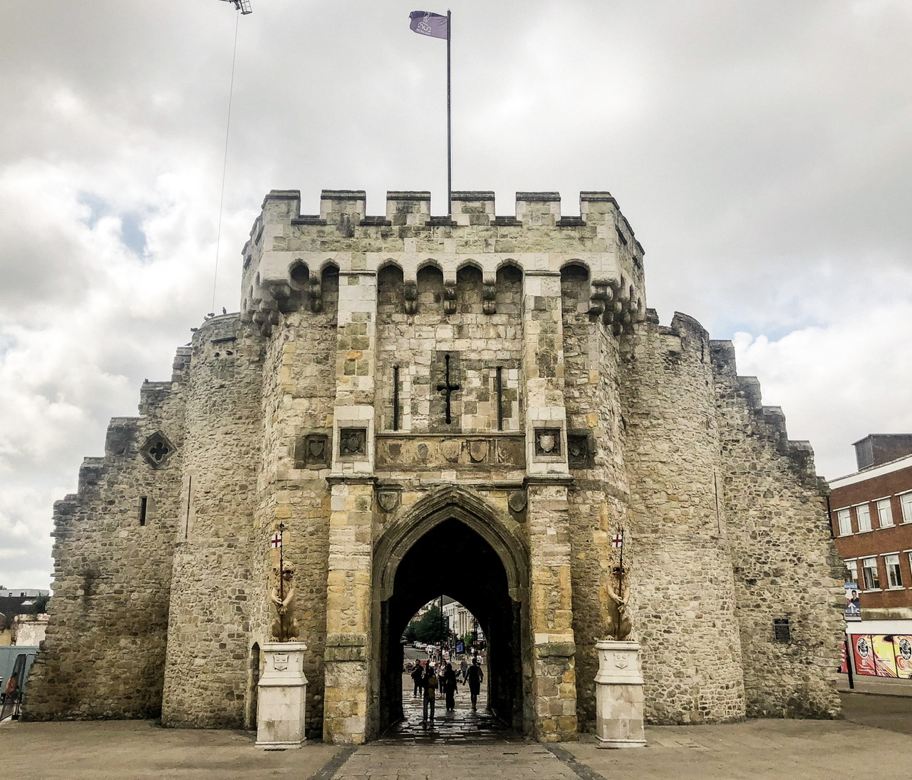 Exterior of medieval Southampton Bargate with flag flying top centre and lion statues either side of central door