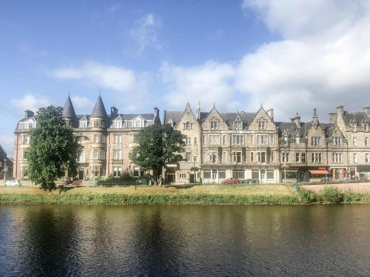 Sandstone buildings viewed across river ness in Inverness