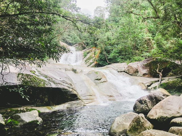 Wide shallow waterfall over rocks with a larger waterfall behind feeding it in the Atherton Tablelands Far North Queensland Australia