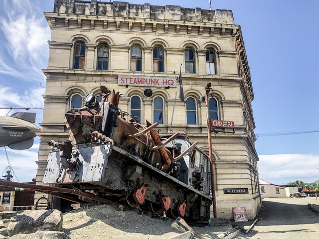 Exterior of whitestone Steampunk HQ building Oamaru. A steampunk style train is parked in the foreground