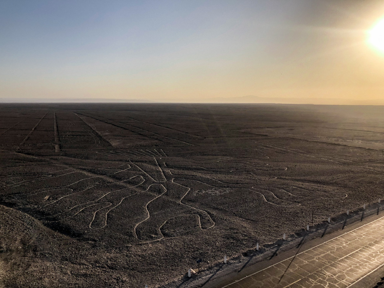 Large squiggly figure of Nazca Lines etched in desert in Peru taken from a public viewing platform