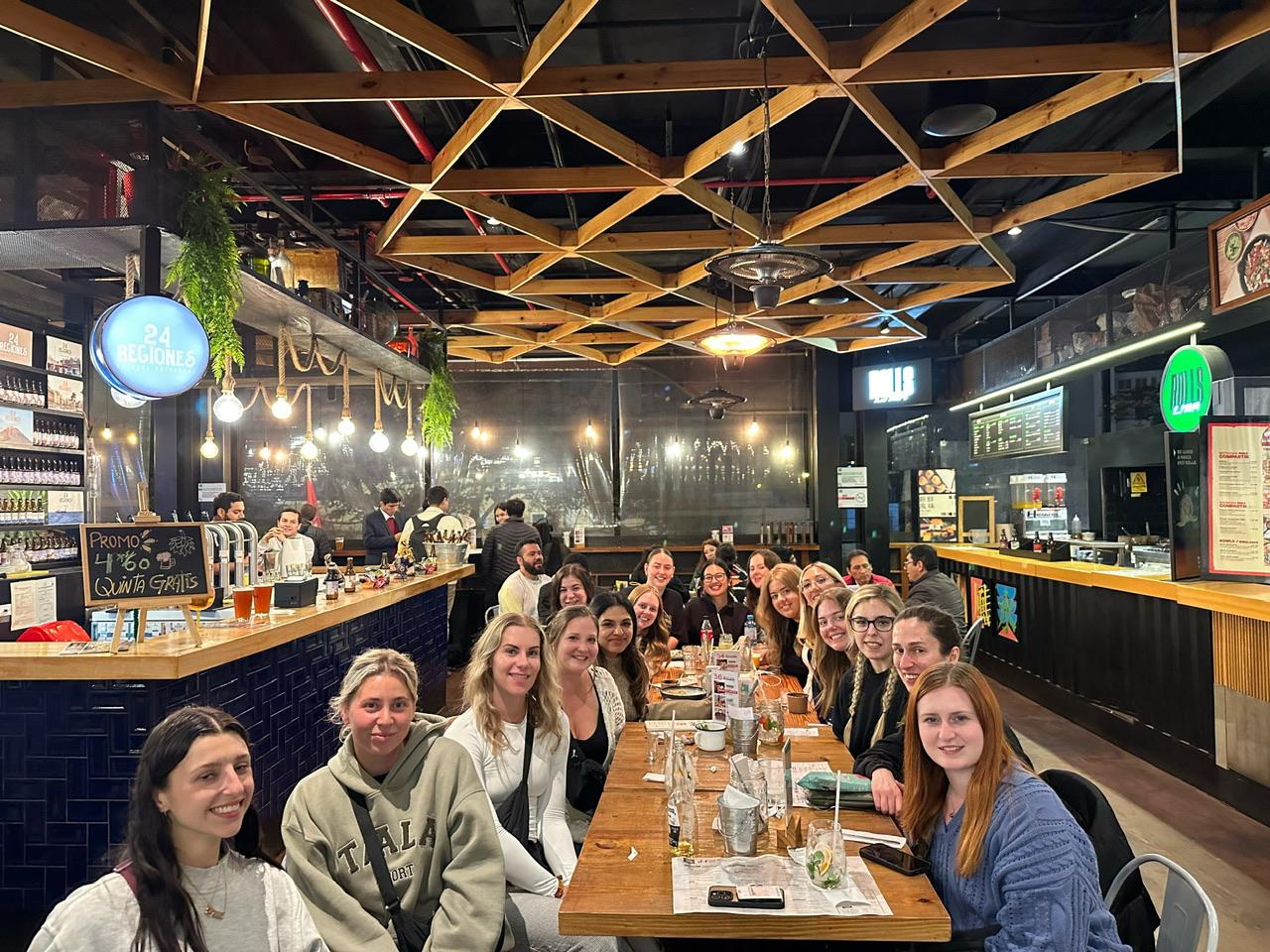 Group of around 19 young women seated eating dinner at at Mercado 28 Miraflores Lima