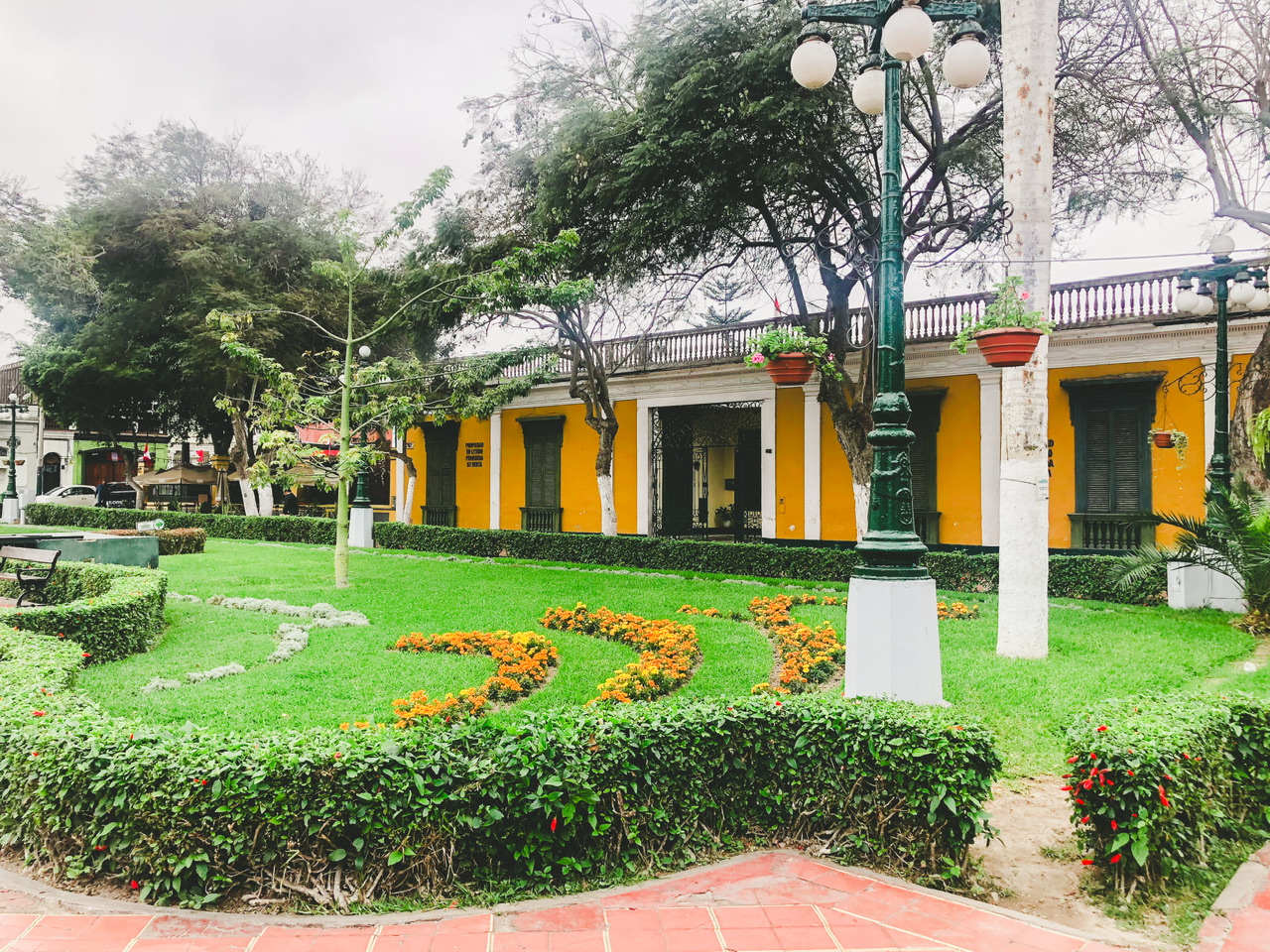 Colourful yellow building and green grace area in Plaza de Armas de Barranco