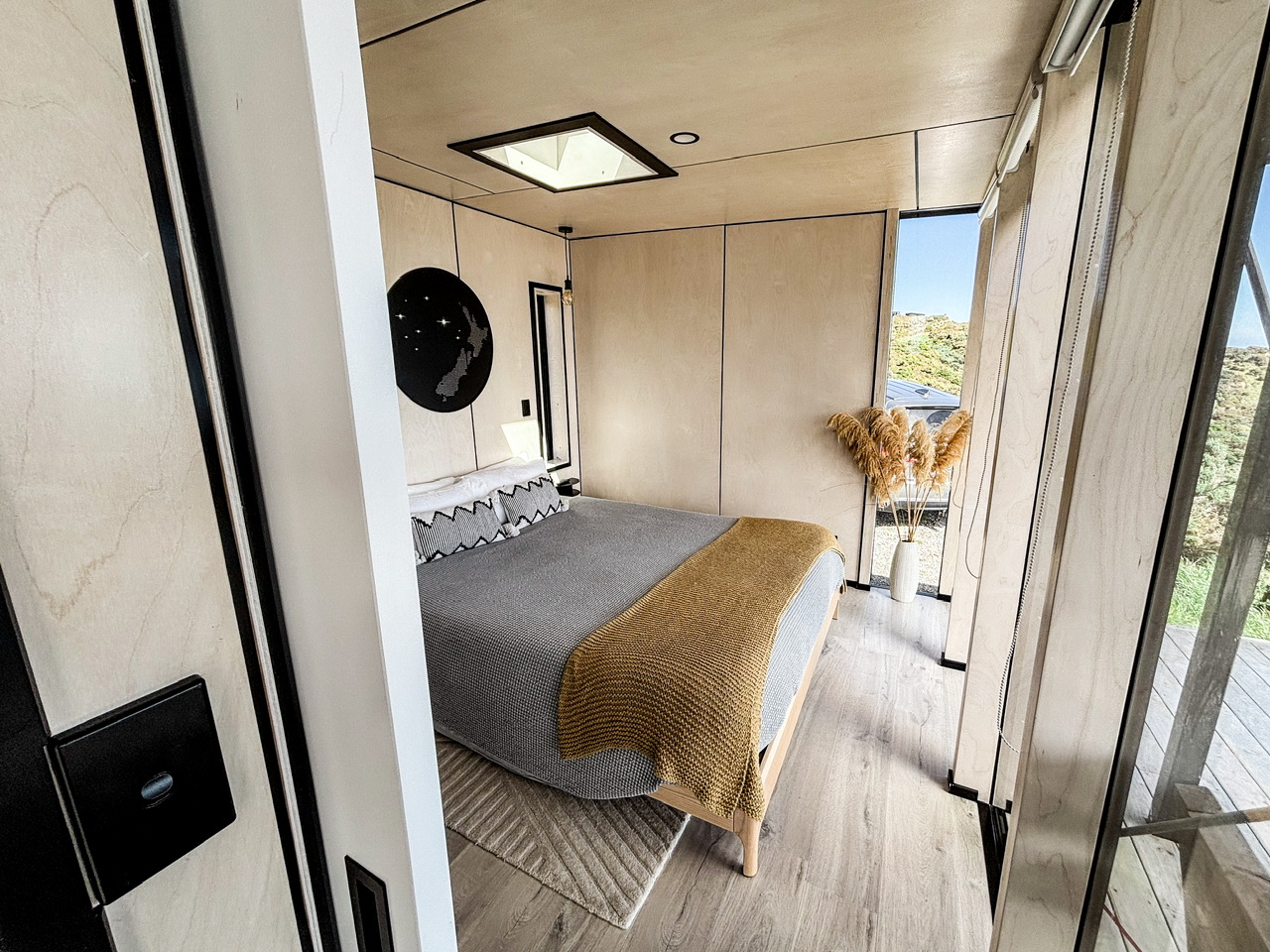 The bedroom at the Ocean House featuring a queen bed and small skylight.